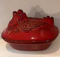 Full view of red ceramic rooster-shaped bakeware with lid on