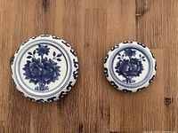 Top view of two blue and white porcelain plant stands showing floral patterns and decorative border