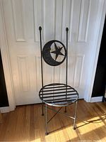 Front view showing wrought iron frame, slatted seat, and decorative star and crescent moon backrest.