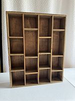 Front view of the wooden display shelf showing multiple compartments for display or storage.