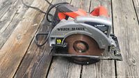 Black & Decker 13 amp circular saw placed on wooden surface, shows top view with blade and part of cord.
