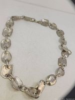 Photo of handmade vintage silver necklace laid flat showing overall design and clasp.
