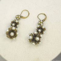 Pair of vintage mid century sputnik style earrings with gold-tone metal and faux pearls. One earring shows a missing pearl as noted by the seller.