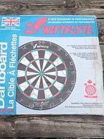 Top view of the closed original SwiftFlyte dartboard box showing the branded design, flags, and dartboard image with regulation markings