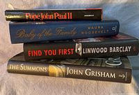 Stacked view showing the spines of the four books titled 'Pope John Paul II', 'Baby of the Family', 'Find You First', and 'The Summons'