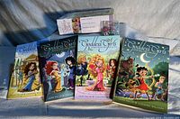 Four Goddess Girls paperback books arranged in a row, showing front covers with colorful cartoon-style illustrations of girls in mythological themes.