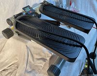 Sunny Health and Fitness mini stepper angled view showing foot pedals, resistance bands, and digital monitor.