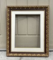 Full front view of ornate gold and burnt amber picture frame showing overall condition and design.