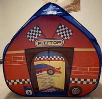 Front view of the pop up play tent with pitstop racing flags and car design.