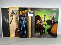 Four vinyl record albums standing upright showing spines and partial front covers.
