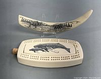 Cribbage board and decorative tusk displayed together showing size and design details