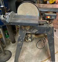 General view of Craftsman belt and disc sander showing the sanding belt with work table, disc sander, motor and power switch on a metal stand.
