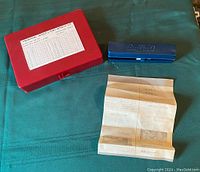 Image showing Buffalo impact driver in blue metal case and a folded instruction manual on teal fabric surface.