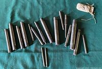 Photo of assorted machinist mandrels and reamers laid out on a green cloth, showing various lengths and diameters.