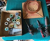 Overview photo of the lot showing copper tubing coil, three soldering irons, and boxed solder wire rolls.