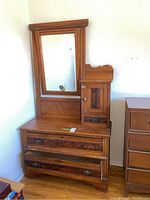 Front view of vintage gentleman's dresser featuring a large mirror, two bottom drawers, and a right side cabinet with door.