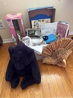 Wide view showing a large black teddy bear, vintage magazines, Easter bunnies in boxes, and a wooden bird sculpture.