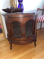 Full view of the drum table showing wood finish, wire mesh doors, and curved legs.