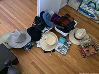 Overview of hats, scarves, foot warmer and torque items grouped on wood floor