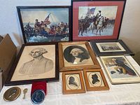 Wide view showing all framed prints and collectibles arranged on table.