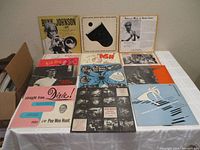 Full spread view of first set of 10-inch vinyl records on table showing ten albums including Bunny Johnson and Pee Wee Hunt.