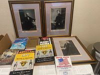Lot of three framed presidential pictures of Pierce, Tyler, and Fillmore, several military history books, and a set of Mothers Cookies Presidential cards shown on a table.