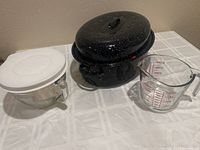 Full view of all three items: stove-top roasting pan with lid, Pampered Chef batter bowl with lid, and glass measuring cup.