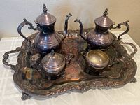 Top angled view of complete 5-piece silver plate tea set displayed on large ornate tray showing all pieces and tray details.