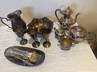 Silver plated coffee and tea set, decorative bowl, goblets, large pitcher, serving tray with utensils.