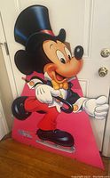 Mickey Mouse cardboard stand-up dressed in formal attire with ice skates and cane, standing 45 inches tall against a white door, showing some edgewear but vibrant colors.