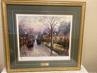 Framed Thomas Kinkade print 'San Jose Hometown Christmas' hanging on a wall, showing the overall artwork and frame.