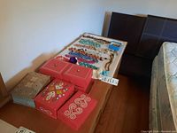Wide angled image showing multiple decorative jewelry storage boxes and strands of costume jewelry laid out on a table.