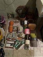 Wide shot showing entire lot, including stacked clay pots, wasp traps, ceramic decorated planters, garden stones, and other items