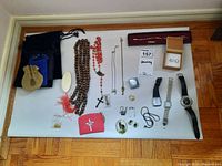 Display of all jewelry including earrings, necklaces, watches, bracelet, and storage pouches on the floor.