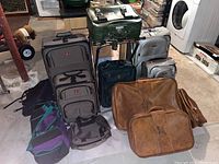 Overall photo showing all luggage pieces grouped together including rolling suitcases, leather briefcases, and duffle bags.