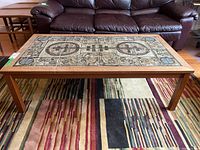 Frontal view of Mid-Century Modern rectangular coffee table with wood frame and decorative tile top showing full design.