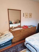 Front view of teak dresser and attached mirror with top surface items