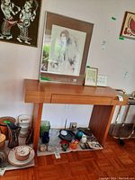 Front view of teak hall table with single central drawer, showing straight side supports.