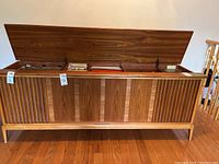 Front view of teak console with top open showing three storage compartments
