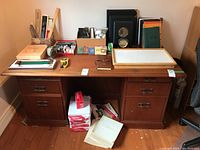 Full view of the wooden office desk with various office supplies arranged on top and underneath.