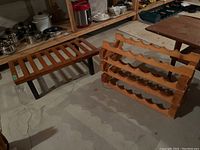 Overall view of wooden wine rack stacked beside the footstool in a basement setting