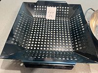 Top view of black square perforated BBQ grilling dish