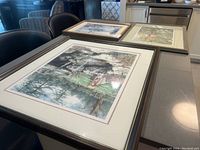 Three framed art prints on table: Keirstead Thousand Islands, Bryant, and Laura Berry numbered print