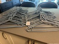 Top down view of light gray plastic hangers spread out across a kitchen counter.