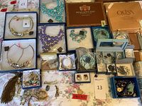 Wide view showing assortment of necklaces, bracelets, brooches, rings, earrings, and decorative cigar boxes