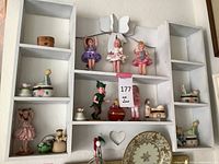 White shelf with small decorative items including porcelain Limoges trinket boxes, ballerina dolls in tutus, and various figurines
