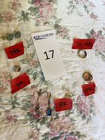 Overview of all jewelry pieces on floral background with red tape karat labels and lot number card