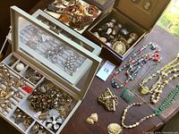 Overview of three open cases showing all jewelry pieces laid out