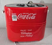 Front view of red Coca-Cola branded hot dog toaster showing logos and slogans.