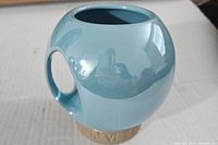 Light blue orb-shaped ceramic mug from Star Wars Galaxy's Edge, showing side handle and glossy finish.